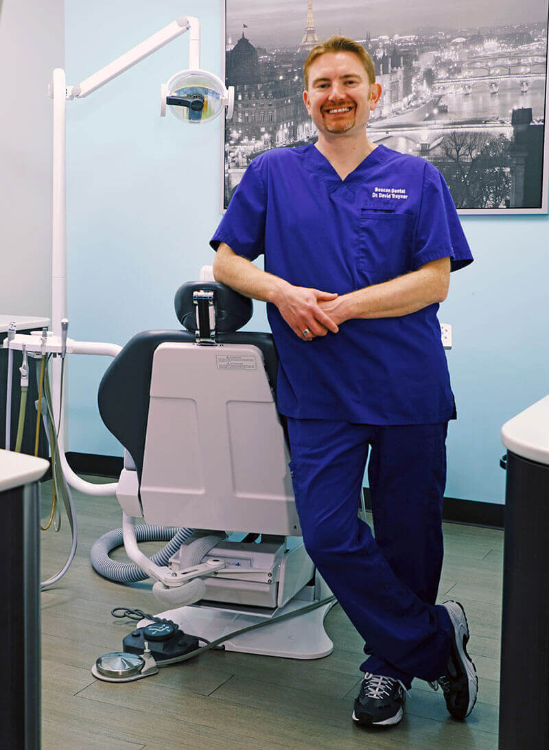full length shot of Dr. Traynor by a dentist chair