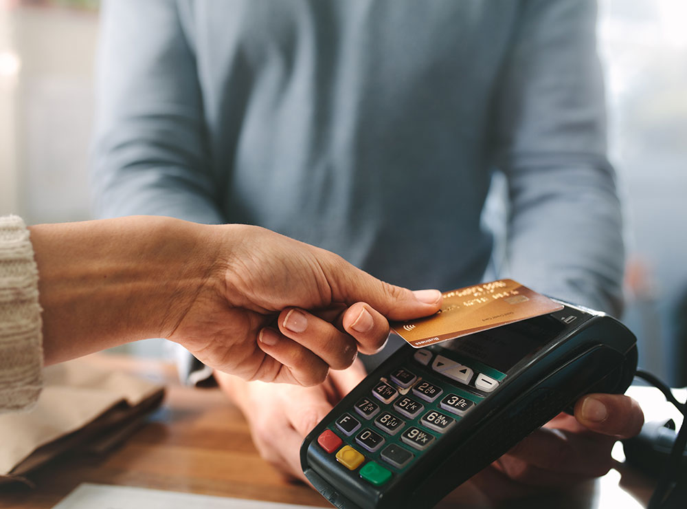 hand swiping credit card at point of sale machine