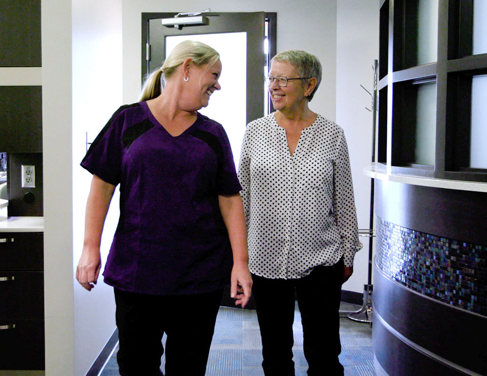 hygenist walking down hallway, talking with patient