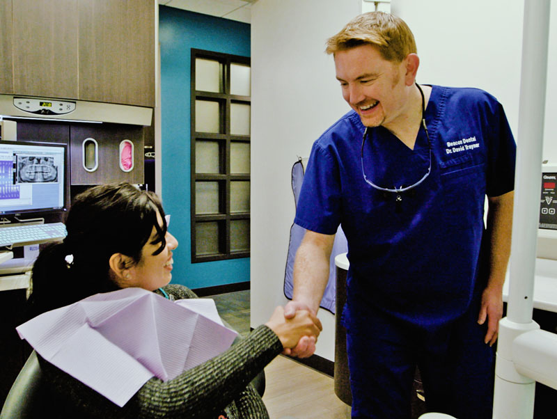 Dr. Traynor shaking hands with a seated female patient